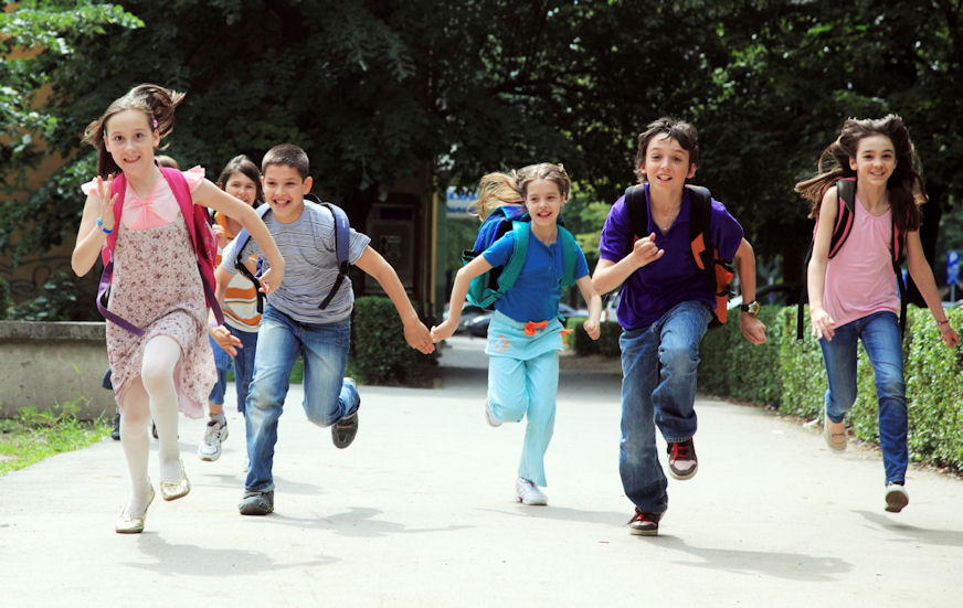 School children pupils running outside.